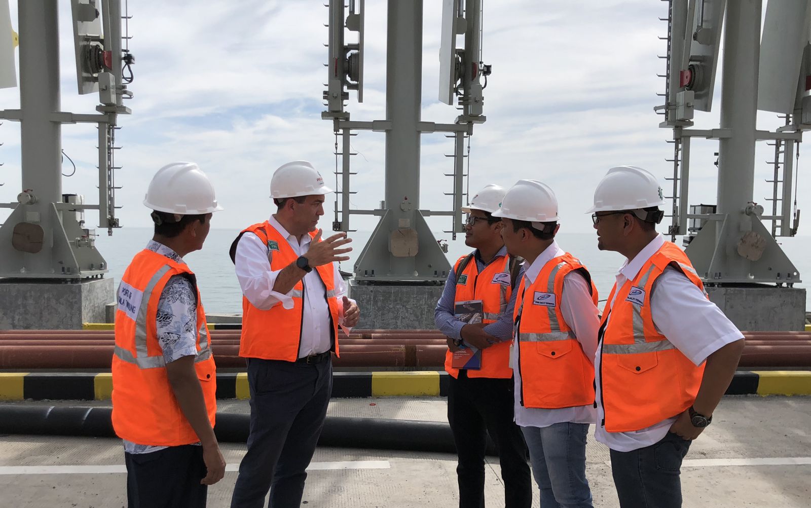 photo, David Bohigian and four other men talk while at a port, OPIC, Overseas Private Investment Corporation, Indonesia, Kuala Tanjung Port, Malacca, development, manufacturing, investment, emerging markets, public diplomacy, national security, investing overseas