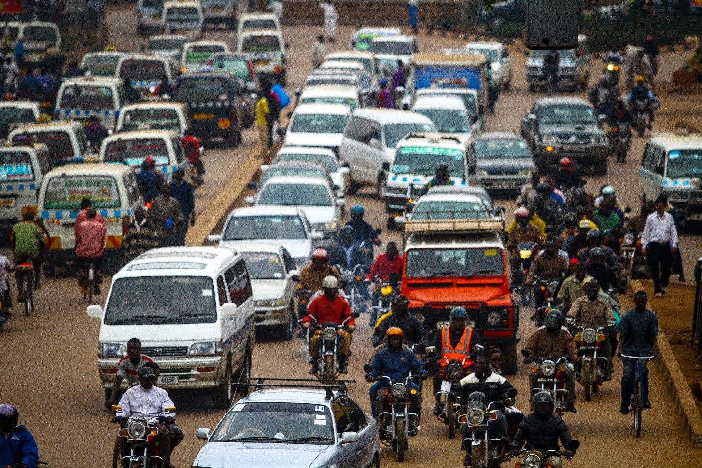 photo of busy street in Uganda filled with cars and motorcycles, Tugende Limited, OPIC, Overseas Private Investment Corporation, Uganda, financing, emerging markets, public diplomacy, private sector, development finance, doing business in Africa, infrastructure, lease to own financing, motorcycle taxi, Connect Africa
