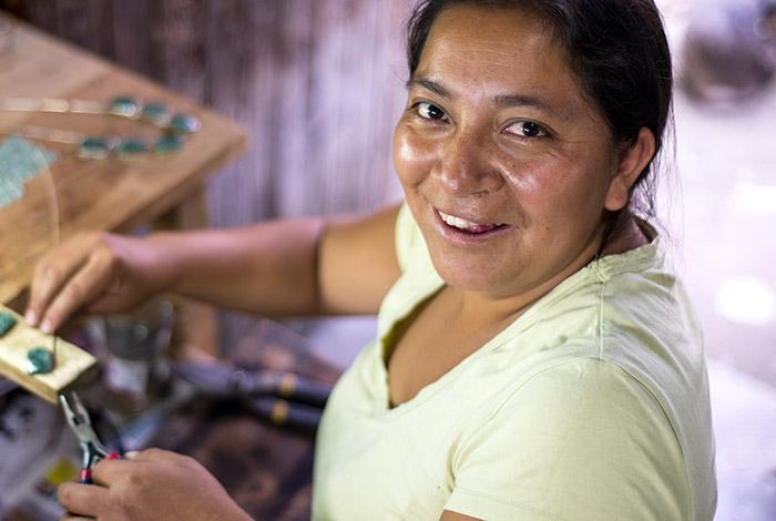 photo, woman creating jewelry and smiling