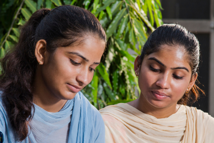Two Indian schoolgirls looking at their schoolwork