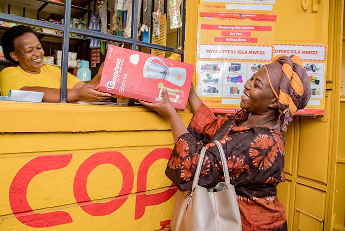 An African woman purchases an appliance from a COPIA store