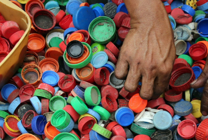 Hands sorting plastic bottle caps