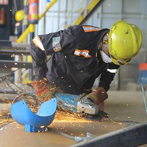 photo, Alistar James employee uses a grinder