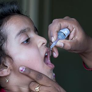 photo, girl in India receiving polio vaccine