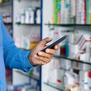 Man holding a phone in a pharmacy